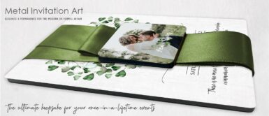 Metal invitation laying prone with a green magnetic ribbon closure